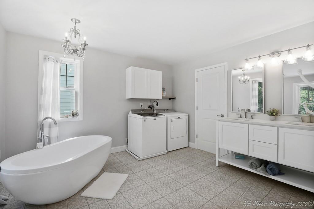 30 Folly Mill Road Salisbury, MA 01952 - Photo 27 of 42 a spacious bathroom with a double vanity sink a mirror a bathtub and a window