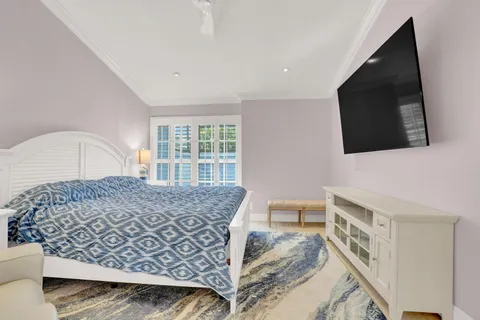 a living room with a bed furniture and a flat screen tv