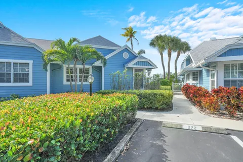 a front view of a house with a yard and potted plants