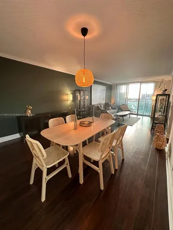 a dining room with wooden floor a chandelier a glass table and chairs