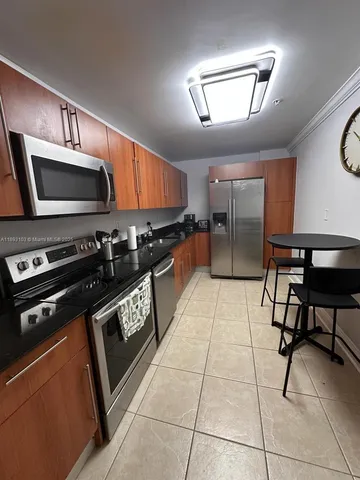 a kitchen with stainless steel appliances kitchen island granite countertop a stove a sink and a microwave