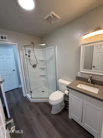 a bathroom with a granite countertop sink toilet a mirror and shower