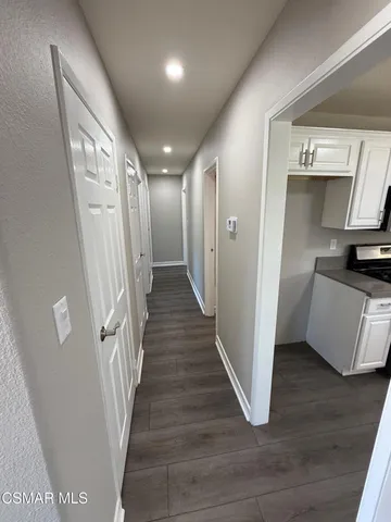 a view of a hallway with wooden floor and stairs