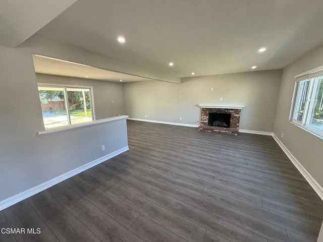 an empty room with wooden floor and a window