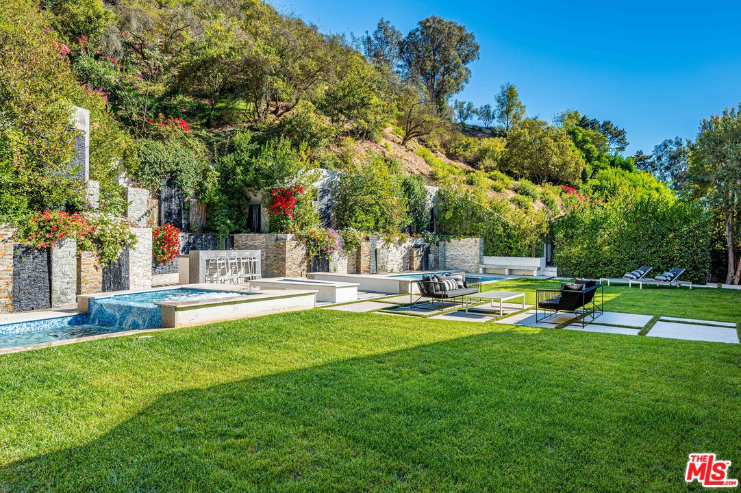 930 Roscomare Road Los Angeles, CA 90077 - Photo 18 of 54 a view of a swimming pool with a big yard