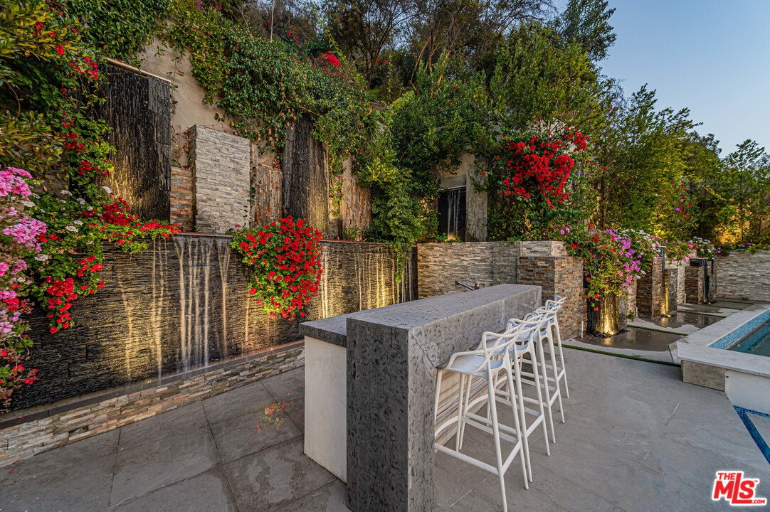 930 Roscomare Road Los Angeles, CA 90077 - Photo 2 of 54 a view of a patio with table and chairs and potted plants