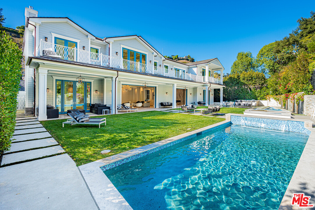 930 Roscomare Road Los Angeles, CA 90077 - Photo 3 of 54 a front view of a house with a yard table and chairs