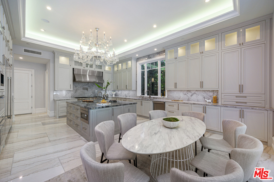 930 Roscomare Road Los Angeles, CA 90077 - Photo 32 of 54 a kitchen with stainless steel appliances granite countertop a kitchen island a stove a dining table and chairs