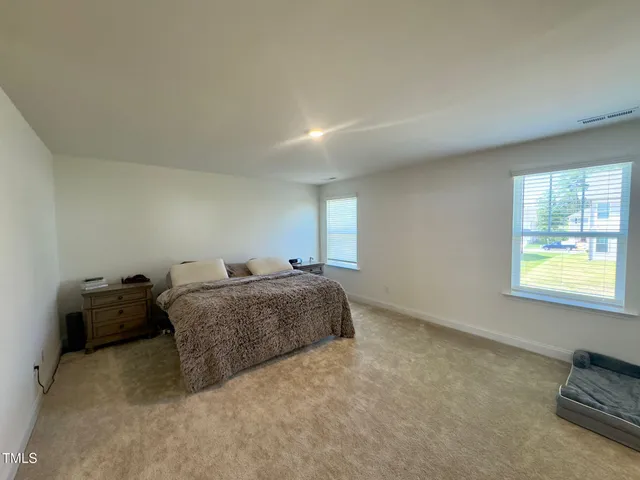 a spacious bedroom with a bed and a window