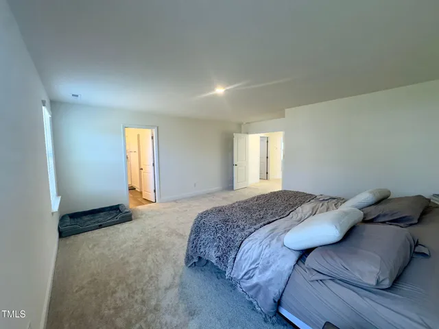 a spacious bedroom with a bed and a window