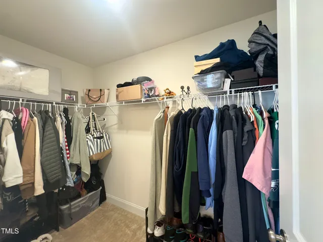 a view of walk in closet with clothes