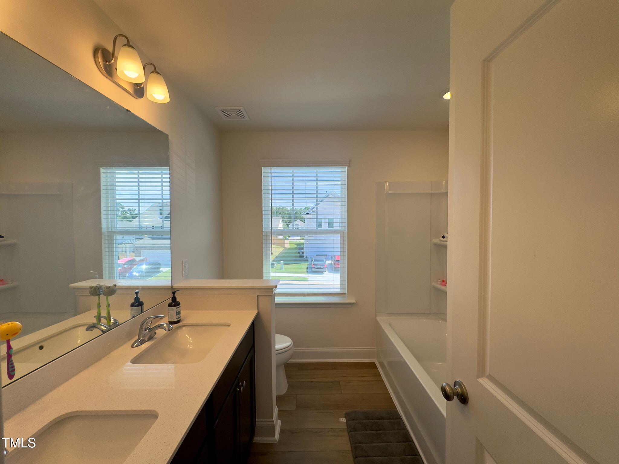 47 Flowing River Road Angier, NC 27501 - Photo 31 of 38 a bathroom with a sink a mirror and a bathtub