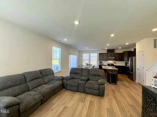 a living room with furniture and kitchen view