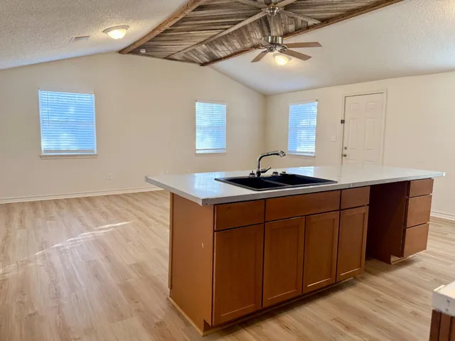 a kitchen with stainless steel appliances granite countertop a sink a stove cabinets and wooden floor