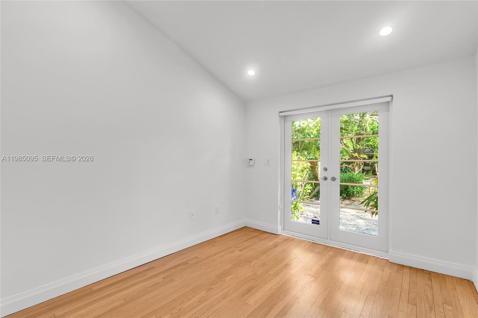 776 Northeast 74th Street Miami, FL 33138 - Photo 16 of 40 a view of an empty room with wooden floor and a window