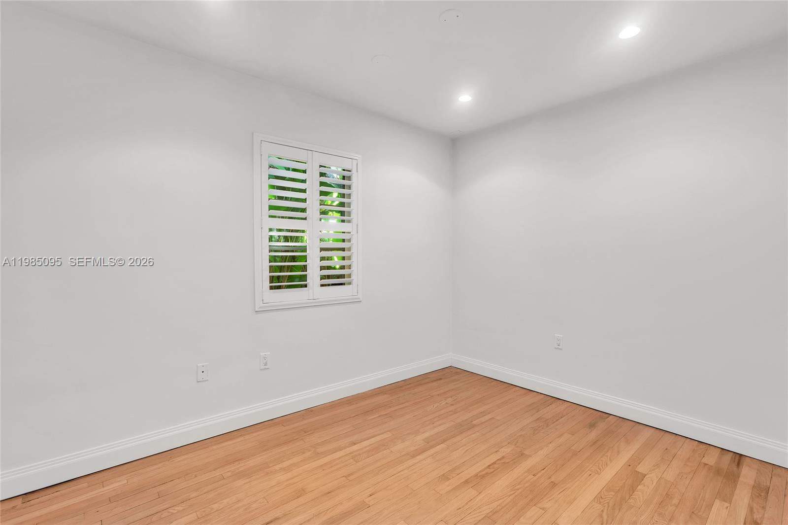 776 Northeast 74th Street Miami, FL 33138 - Photo 19 of 40 an empty room with wooden floor and windows