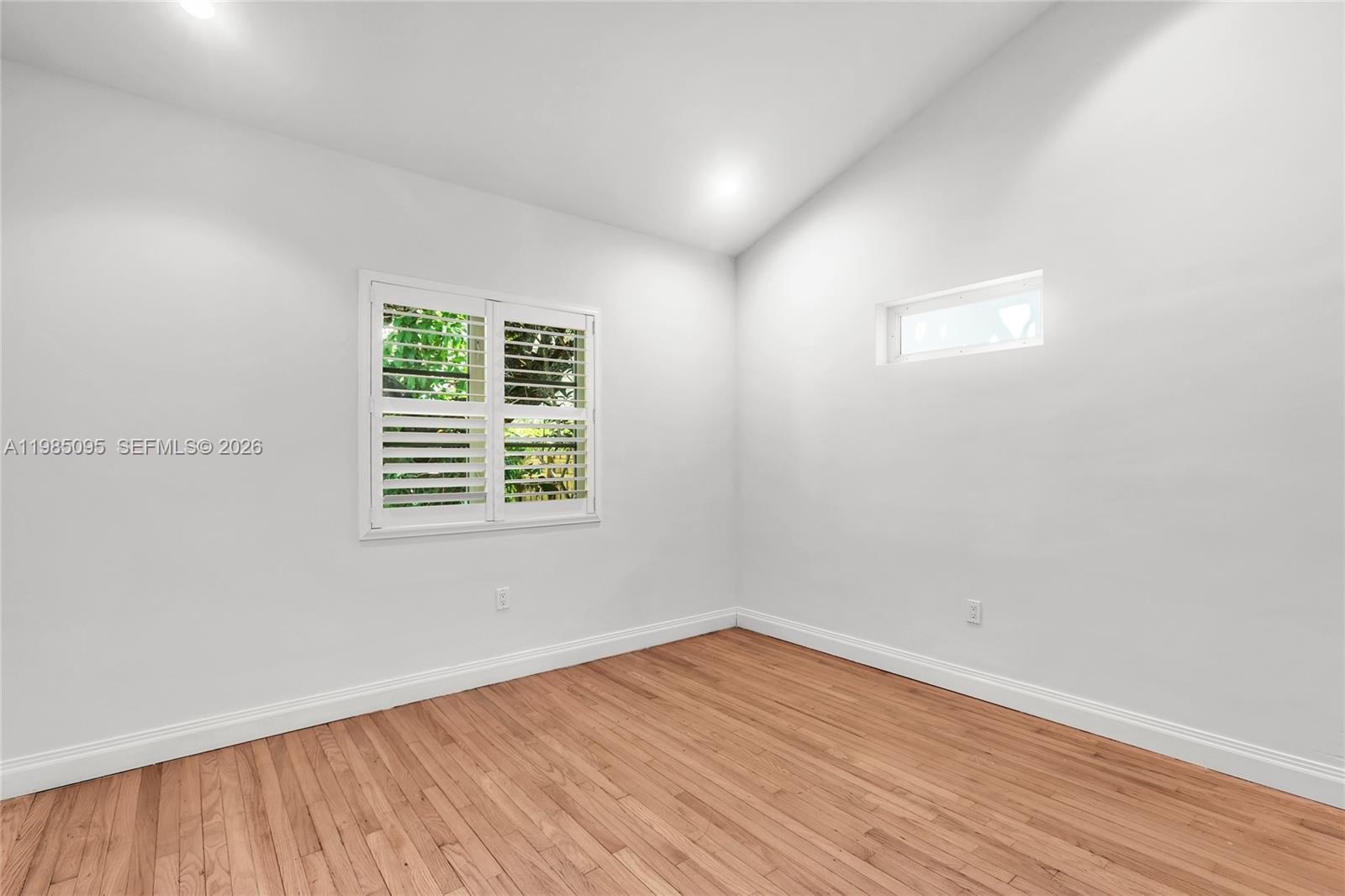 776 Northeast 74th Street Miami, FL 33138 - Photo 23 of 40 wooden floor in an empty room with a window