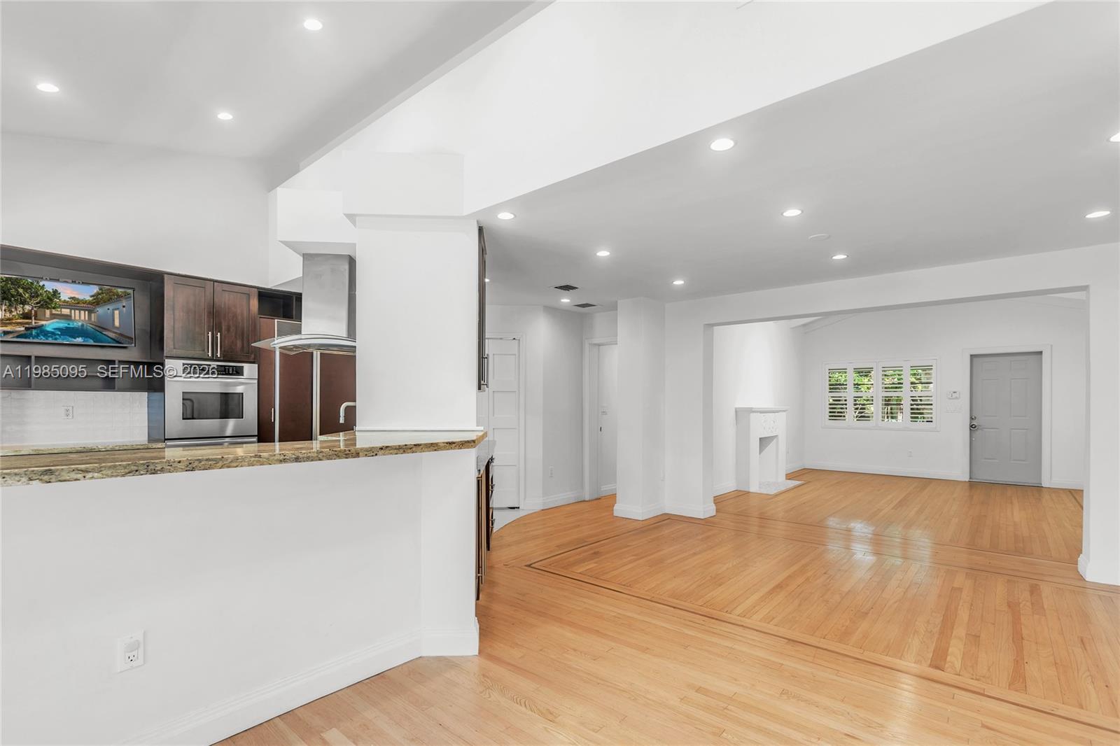 776 Northeast 74th Street Miami, FL 33138 - Photo 8 of 40 a large white kitchen with kitchen island a counter top space and stainless steel appliances