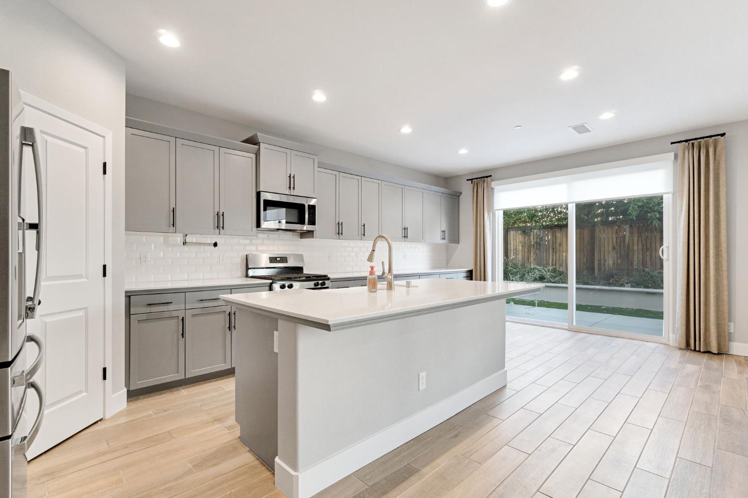 4415 Horizon Drive Madera, CA 93636 - Photo 11 of 41 a large kitchen with stainless steel appliances granite countertop a lot of counter space and wooden floors