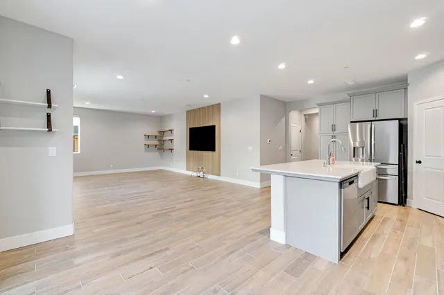 a kitchen with stainless steel appliances kitchen island wooden floors granite counter tops and white cabinets