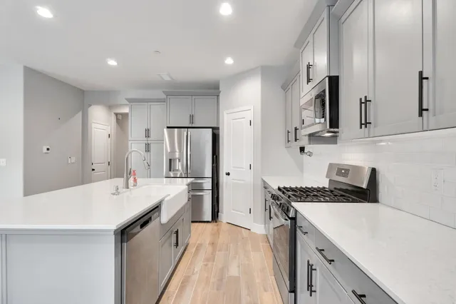 a kitchen with stainless steel appliances a sink stove and refrigerator