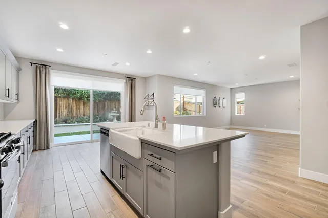 a large kitchen with stainless steel appliances granite countertop a lot of counter space and wooden floor
