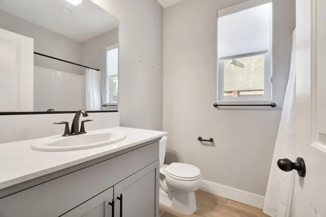 a bathroom with a sink a toilet and mirror