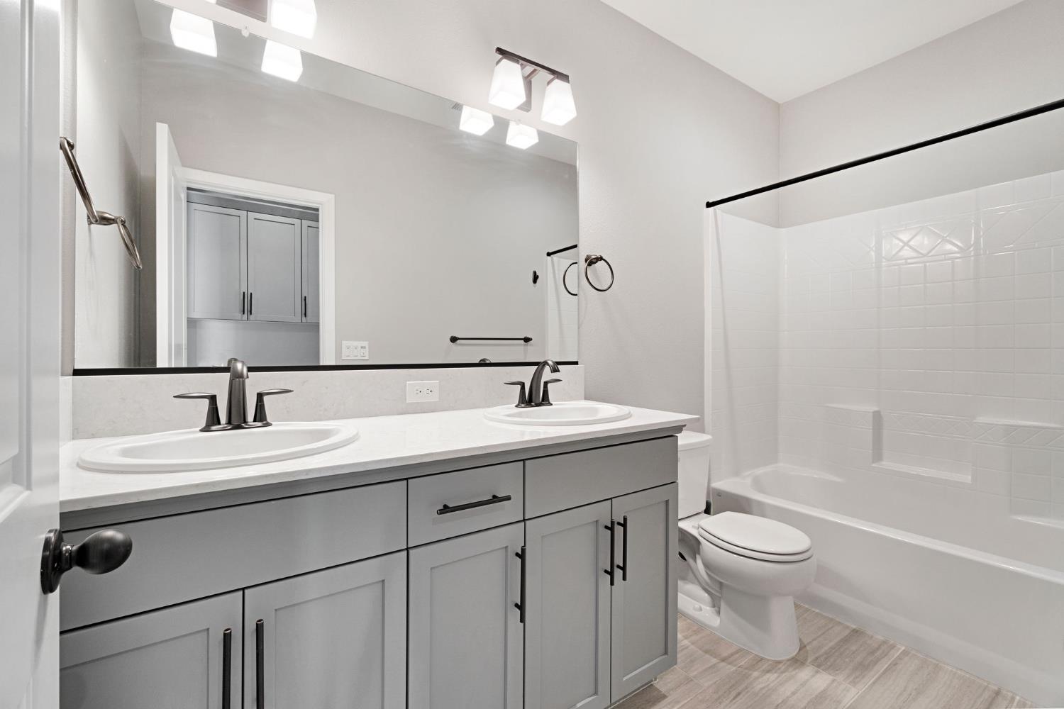4415 Horizon Drive Madera, CA 93636 - Photo 26 of 41 a bathroom with a toilet a sink a mirror a bathtub and vanity