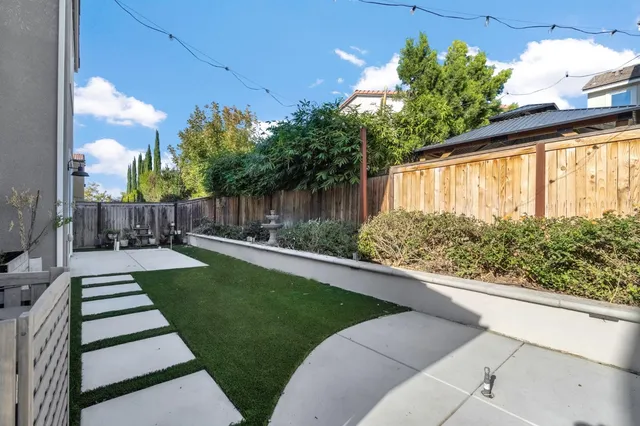 a view of a back yard with flower plants and wooden fence