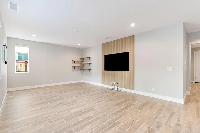 a view of a livingroom with wooden floor and a flat screen tv