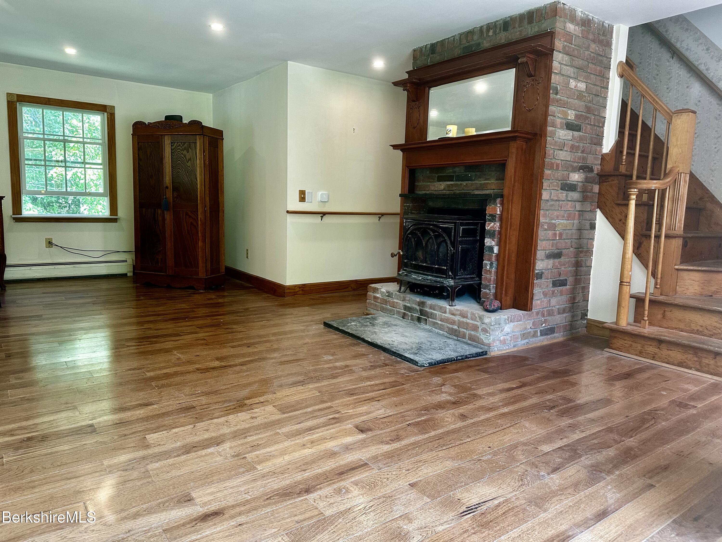 1689 East Windsor Road Windsor, MA 01270 - Photo 24 of 57 a view of a livingroom with a fireplace wooden floor and staircase