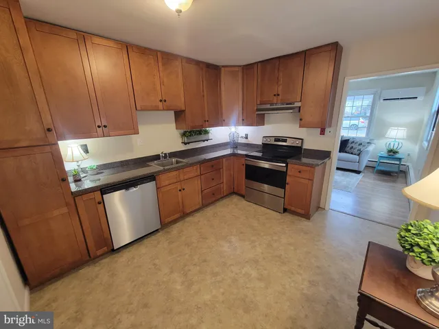 a kitchen with granite countertop a sink stove and cabinets