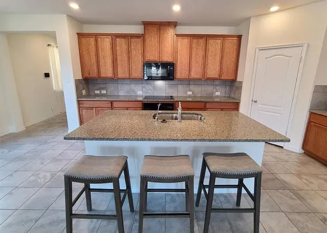 a kitchen with a table chairs microwave and cabinets