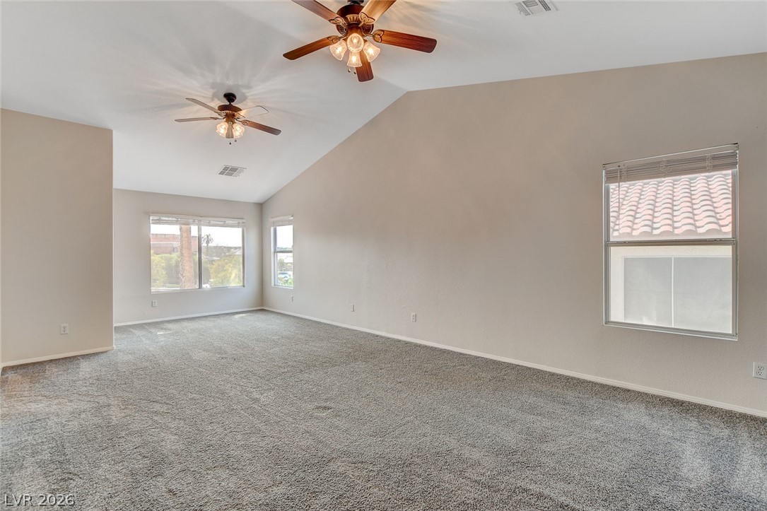 191 Verde Ridge Court Henderson, NV 89012 - Photo 19 of 36 Carpeted spare room featuring a ceiling fan, lofted ceiling, and baseboards