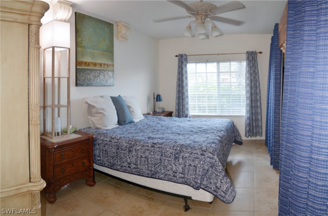 20121 Estero Gardens Circle, Unit 101 Estero, FL 33928 - Photo 15 of 24 a bedroom with a bed and window
