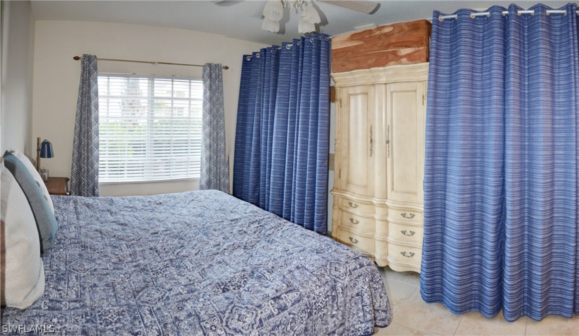 20121 Estero Gardens Circle, Unit 101 Estero, FL 33928 - Photo 17 of 24 a bedroom with a bed and a dresser next to a window