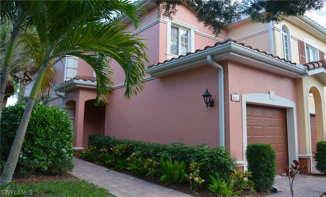 20121 Estero Gardens Circle, Unit 101 Estero, FL 33928 - Photo 2 of 24 a front view of a house with garden