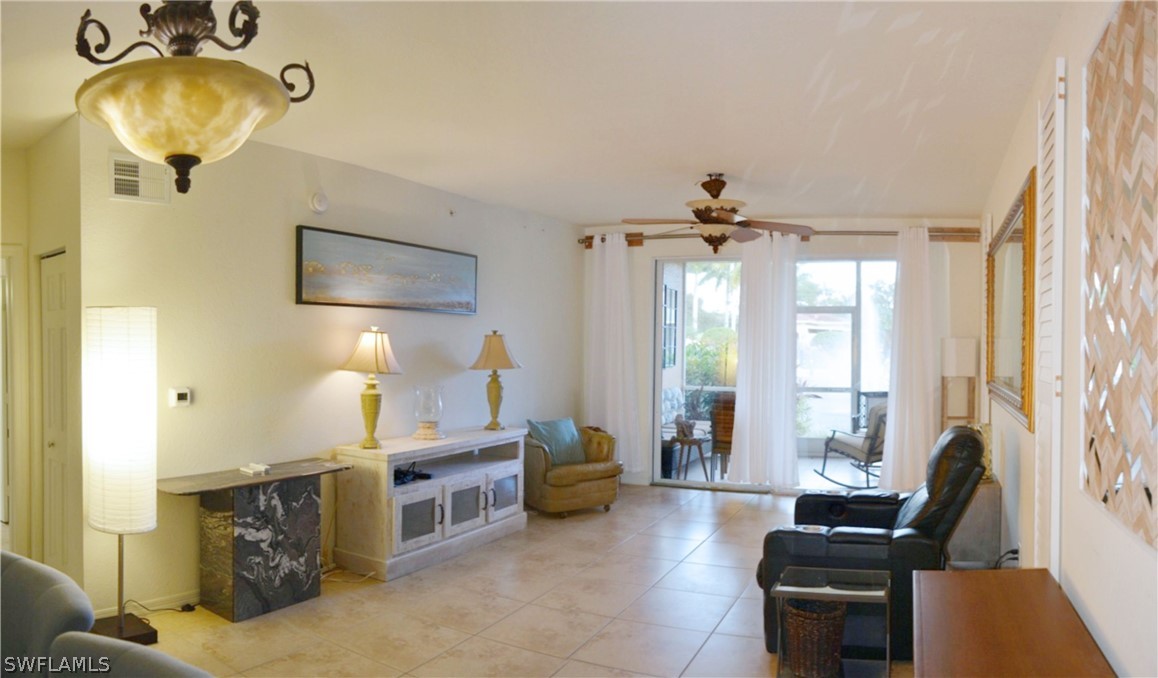 20121 Estero Gardens Circle, Unit 101 Estero, FL 33928 - Photo 3 of 24 a living room with furniture and a chandelier