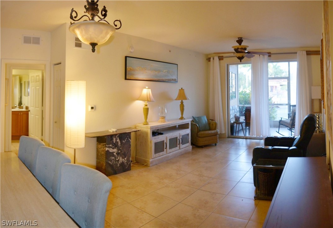 20121 Estero Gardens Circle, Unit 101 Estero, FL 33928 - Photo 4 of 24 a living room with furniture and a flat screen tv