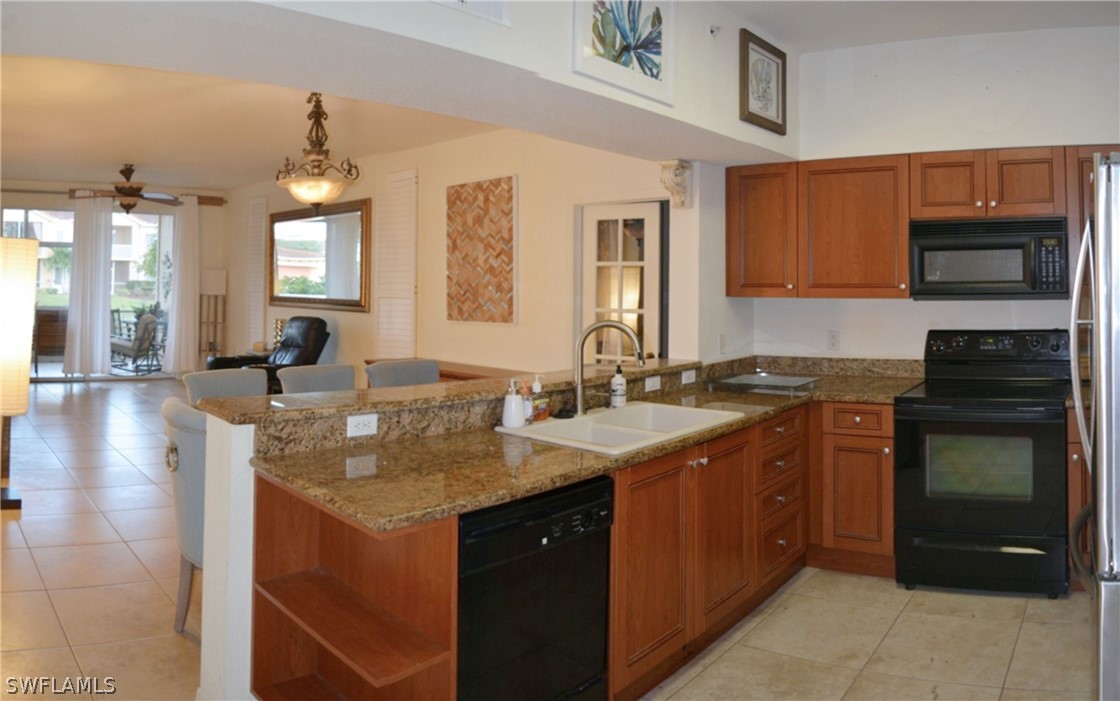 20121 Estero Gardens Circle, Unit 101 Estero, FL 33928 - Photo 6 of 24 a kitchen with stainless steel appliances granite countertop a sink stove and cabinets