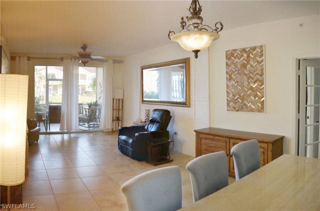 20121 Estero Gardens Circle, Unit 101 Estero, FL 33928 - Photo 7 of 24 a living room with furniture and a chandelier