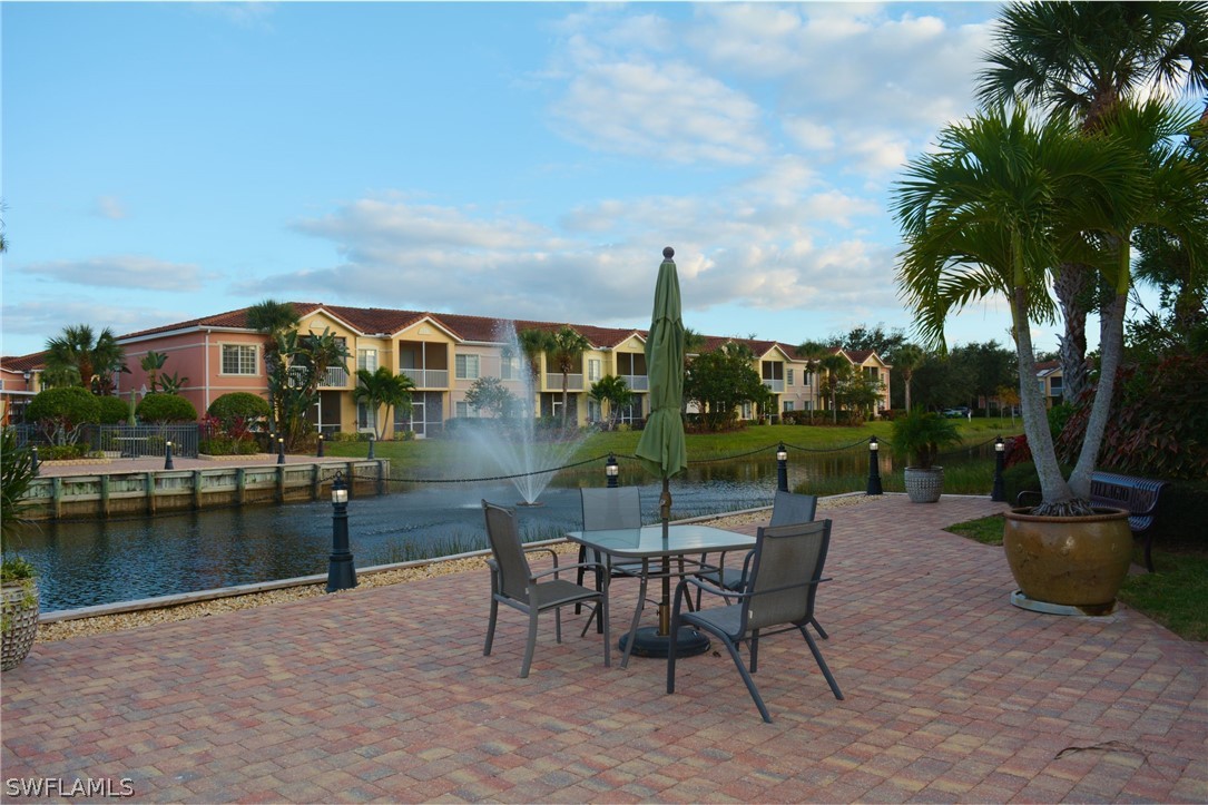 20121 Estero Gardens Circle, Unit 101 Estero, FL 33928 - Photo 8 of 24 a view of a patio with a table and chairs