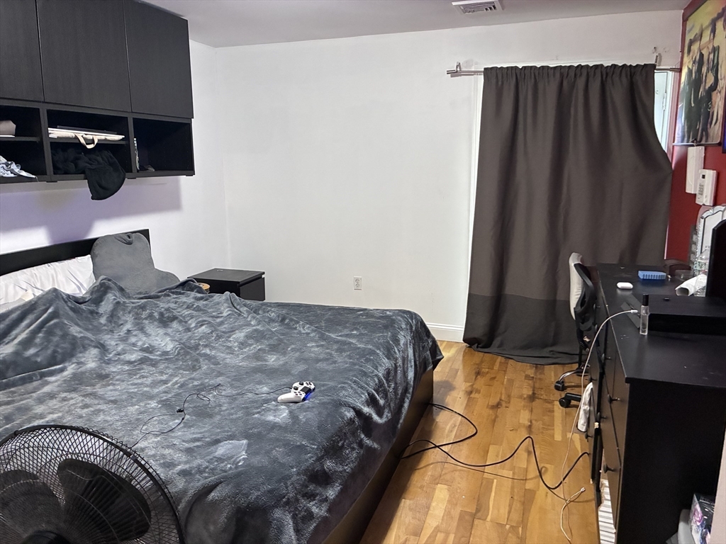 25 Alpine Street, Unit 7 Boston, MA 02136 - Photo 7 of 16 a bed sitting in a bedroom next to a window