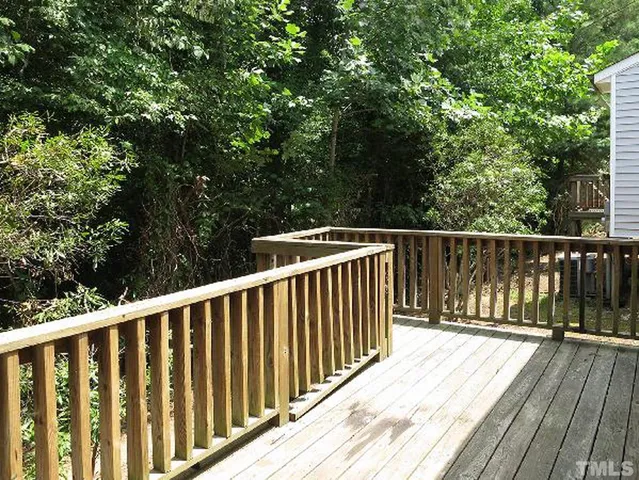a balcony with wooden floor and fence