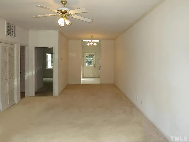 an empty room with fan and entrance