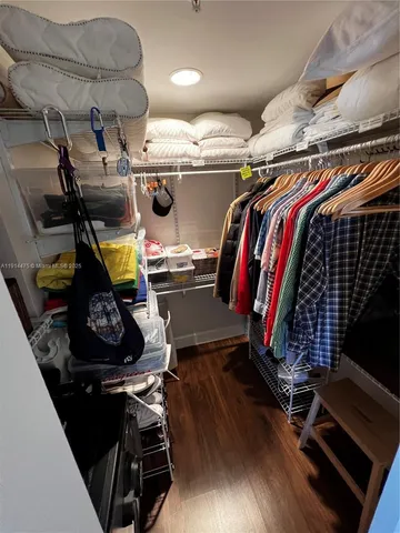 a view of walk in closet with clothes and shoes