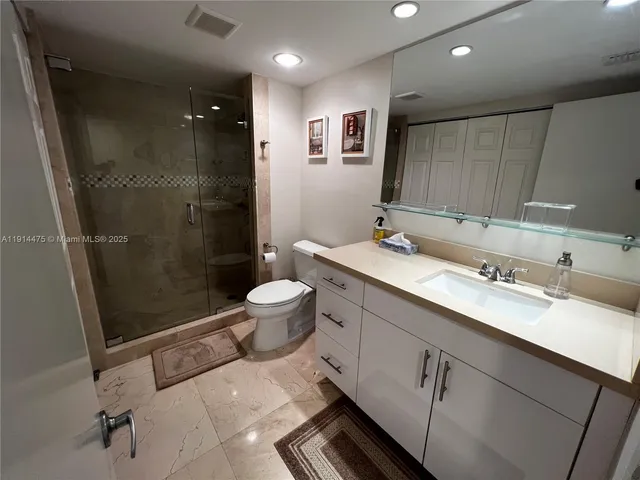a bathroom with a double vanity sink toilet and shower