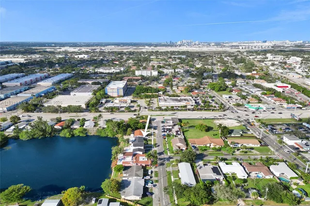 an aerial view of a city with lots of residential buildings ocean and mountain view in back