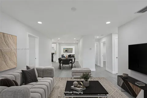 a living room with furniture a rug and a flat screen tv