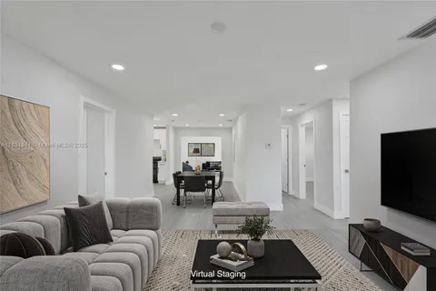 a living room with furniture a rug and a flat screen tv